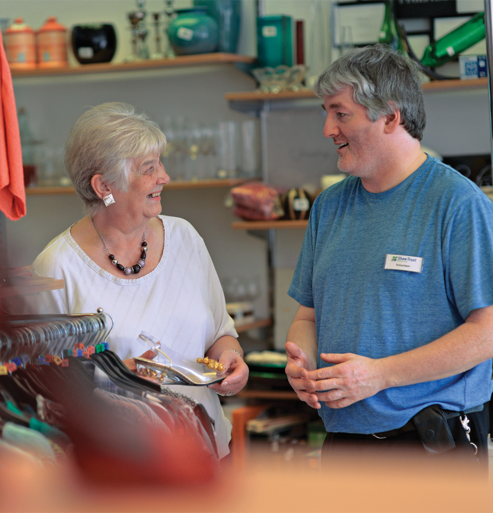 A Shaw Trust shop employee helping a customer