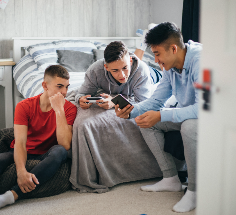 Three young people looking at a phone