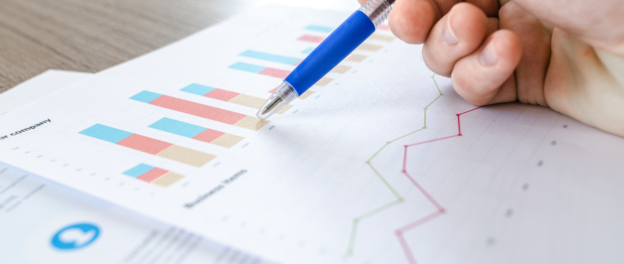 Photo of a person analysing graphs and data on paperwork.