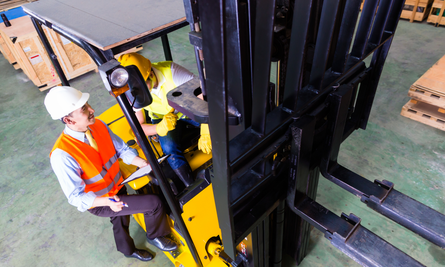 Photo of a man getting some training for driving a forklift truck within a warehouse environment.