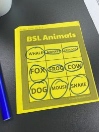 A yellow sheet of paper on a table. There are nine squares with an animal in each - Whale, monkey, crocodile, fox, frog, cow, dog, mouse, snake. All animals have been circled in a blue pen.
